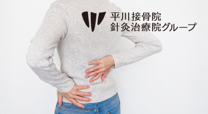 腰に手を当てて痛みを訴える人