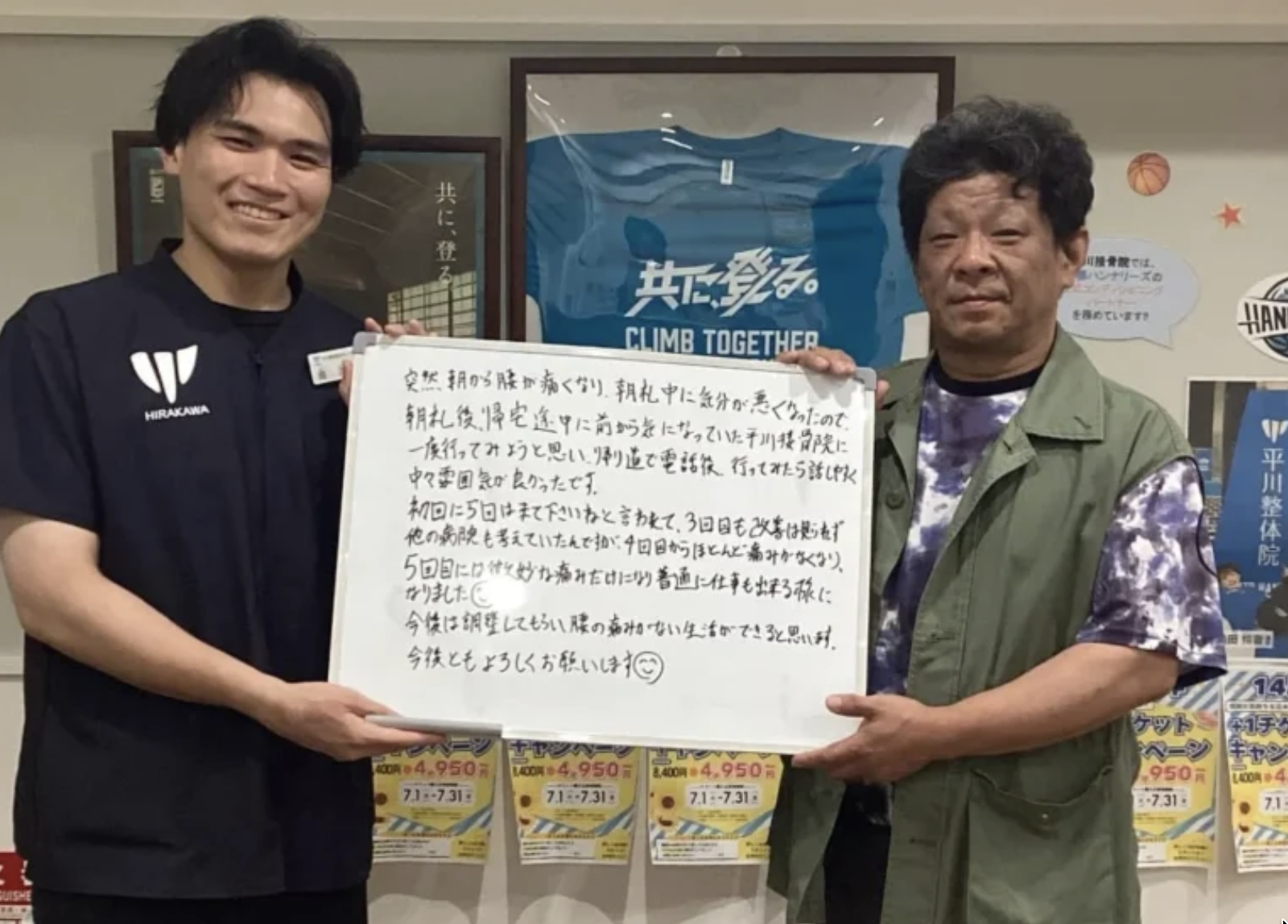施術後の感想を書いたボードを持つ利用者とスタッフ