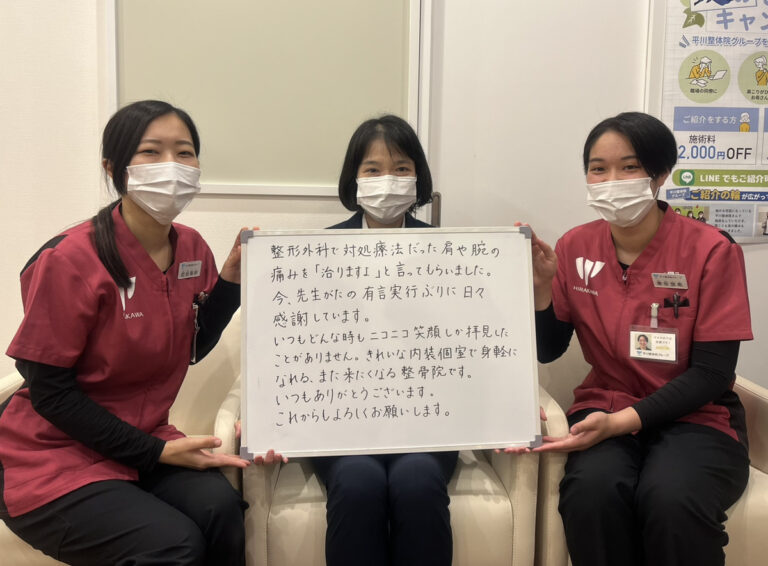 肩や腕の痛みに関する感想ボードを持つ利用者とスタッフ